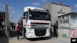 Hamas police officers check a tanker truck carrying fuel as it is cleared to enter the Palestinian side of the Kerem Shalom cargo crossing with Israel, in Rafah, southern Gaza Strip, Aug. 8, 2022. 