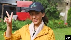 FILE - Pakistani mountaineer Samina Baig flashes a victory sign while she poses for a photograph outside a hotel, in Skardu, Pakistan, June 17, 2021.