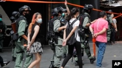 Polisi tampak menahan sejumlah peserta demo di area Causeway Bay di Hong Kong, pada 1 Juli 2020. Peserta menggelar protes dalam peringatan penyerahan kekuasaaan di wilayah Hong Kong dari pemerintah Inggris ke China. (Foto: AP/Kin Cheung)