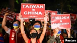 Demonstrators hold signs during a gathering in support of U.S. House of Representatives Speaker Nancy Pelosi's visit, in Taipei, Taiwan Aug. 2, 2022.