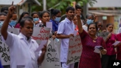 Government hospital staff members shout anti-government slogans condemning the eviction of protesters from the president's office using military force in Colombo, Sri Lanka, July 23, 2022.