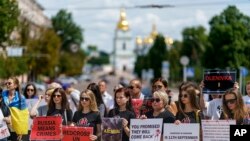Protesters attend a rally in support of Ukrainian soldiers from the Azov Regiment who were captured by Russia in May after the fall of Mariupol, in Kyiv, Ukraine, Saturday, July 30, 2022.