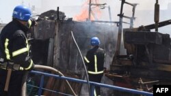 A handout image made available by the Odesa City Council Telegram channel, July 24, 2022, shows Ukrainian firefighters battling a fire on a boat burning in the port of Odesa.