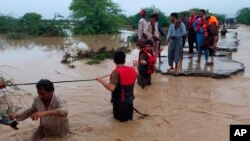 FILE - Tim SAR membantu penduduk desa mengungsi dari banjir setelah hujan lebat, di Lasbella, distrik di provinsi Baluchistan barat daya Pakistan, 26 Juli 2022. (AP/Hamdan Khan, File) Tim pencari Pakistan menemukan puing-puing helikopter yang jatuh Senin, 1 Agustus 2022.