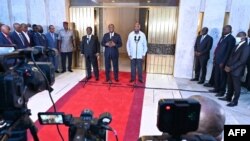 Le président de la Côte d'Ivoire Alassane Ouattara (au centre) s'exprime aux côtés de ses prédécesseurs Laurent Gbagbo (à droite) et Henri Konan Bedie (à gauche) au palais présidentiel d'Abidjan, le 14 juillet 2022. 