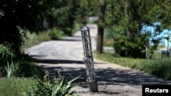 An emptied cluster munition container is seen stuck in the ground following a military strike, amid Russia's attack on Ukraine, on the outskirts of Kharkiv, Ukraine, June 10, 2022. 