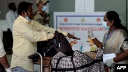 FILE - Health workers screen passengers arriving from abroad for monkeypox symptoms at Anna International Airport in Chennai, India, June 3, 2022.