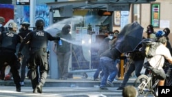 FILE - Police pepper spray protesters near Seattle Central College in Seattle, during a march and protest in support of Black Lives Matter, July 25, 2020. Democratic lawmakers in California, Maryland and Washington passed far-reaching policing reforms in response to the 2020 killing of George Floyd in Minnesota.
