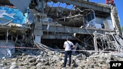 Čovek gleda zgradu supermarketa delimično razorenu raketom, na obodu Kijeva, 8. juna 2022. (Foto: AFP/Sergey Bobok)