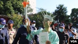 កញ្ញា សេង ធារី មេធាវីខ្មែរ-អាមេរិកាំង តែងខ្លួនជាស្រ្តីនៃសេរីភាព ឈរថ្លែងនៅខាងមុខសាលាដំបូងរាជធានីភ្នំពេញ មុនពេលត្រូវបានចាប់ខ្លួន នៅថ្ងៃទី១៤ ខែមិថុនា ឆ្នាំ២០២២។ (កាន់ វិច្ឆិកា/វីអូអេ)