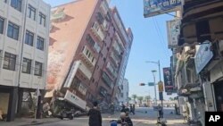 টিভিবিএস প্রদর্শিত একটি ভিডিও ফুটেজ থেকে নেয়া এই ছবিতে ২০২৪ সালের ৩ এপ্রিল তাইওয়ানের পূর্বাঞ্চলের হুয়ালিয়েনে একটি আংশিক ধসে পড়া ভবন দেখা যাচ্ছে। 