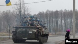 A local woman salutes Ukrainian service members, as Russia's attack on Ukraine continues, in Chernihiv region, April 2, 2022. 