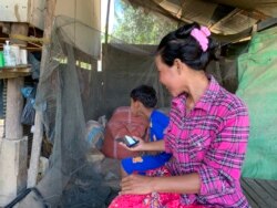 អ្នកស្រី​ សាន ស៊ីណាត អ្នក​ផ្ទុកមេរោគ​អេដស៍​ដែលបានឆ្លងដោយសារ​គ្រូពេទ្យ​ខ្វះ​វិជ្ជាជីវៈ​ចាក់​ថ្នាំ​ដោយ​ប្រើ​សឺរ៉ាំង​រួម​គ្នា អង្គុយ​នៅ​ផ្ទះ​របស់​អ្នកស្រី​ ក្នុង​ភូមិ​រកា ឃុំរកា ស្រុក​សង្កែ ខេត្ត​បាត់​ដំបង នៅ​ថ្ងៃទី២៨ ខែ​មីនា ឆ្នាំ​២០២២។