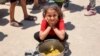 Seorang anak perempuan duduk dengan sepanci nasi yang telah dimasak di kamp Jabalia yang diperuntukkan untuk para pengungsi Palestina di utara Jalur Gaza Strip, pada 13 Juni 2024. (Foto:AFP/Omar Al-Qattaa)