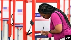 A voter fills out her ballot during the Kentucky Primary at the Kentucky Exposition Center in Louisville, Ky., June 23, 2020.