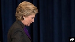 FILE - Democratic presidential candidate Hillary Clinton walks off the stage after conceding to Donald Trump in New York, Nov. 9, 2016. Putting aside partisan politics, Clinton said of Trump "we owe him an open mind and the chance to lead.”