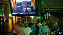 ពលរដ្ឋ​ស៊ីមបាវ៉េ​មើល​ការ​ថ្លែង​សុន្ទរកថា​របស់​លោក​ប្រធានាធិបតី Robert Mugabe នៅ​ក្នុង​បារ​មួយ​កន្លែង​ក្នុង​ក្រុង Harare ប្រទេស​ស៊ីមបាវ៉េ កាលពី​ថ្ងៃទី១៩ ខែវិច្ឆិកា ឆ្នាំ២០១៧។