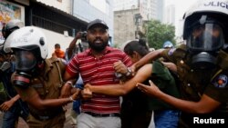 FILE - Sri Lankan police officers detain a demonstrator during an anti-government protest, amid the country's economic crisis, in Colombo, Sri Lanka, Aug. 30, 2022.