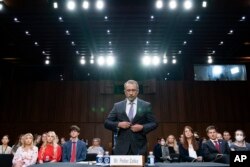 Twitter whistleblower Peiter Zatko buttons his jacket as he rises to be sworn in to testify to a Senate Judiciary hearing examining data security at risk, in Washington, Sept. 13, 2022.