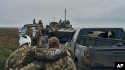 12일 하르키우 수복지에서 진군하는 우크라이나군 병사가 부상당한 전우를 부축하고 있다. 