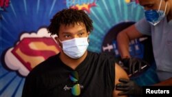 FILE - AJ Weber, 17, receives a Pfizer-BioNTech COVID booster shot at Skippack Pharmacy in Schwenksville, Pa., Sept. 8, 2022. 