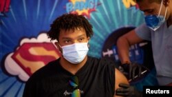 ARHIVA - Mladi Amerikanac prima buster vakcinu farmaceutskih kompanija Fajzer i Bajontek 