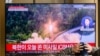FILE - A man watches a television showing a news broadcast with file footage of a North Korean missile test, at a railway station in Seoul on Nov. 18, 2022. 