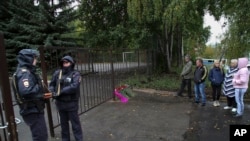 俄罗斯9月26日发生两起枪击案，其中一起发生在俄罗斯中西部乌德穆尔特共和国首府伊热夫斯克第88学校，图为枪击案现场有人献花，有人驻足表示哀悼。第88学校的枪击案造成13人死亡，其中有7名儿童，另外还有21人受伤。-美联社照片