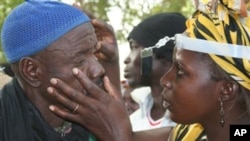FILE - Residents of a village in Mali are screened for trachoma, a neglected tropical disease and the world’s leading infectious cause of blindness, Jan. 23, 2017. (The Carter Center via AP)