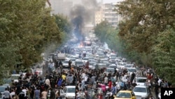 FILE - In this photo obtained by the AP outside Iran, protesters chant slogans during a protest over the death of a woman detained by the morality police, in Tehran, Iran, Sept. 21, 2022.