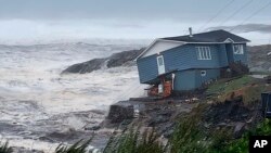 In this photo provided by Wreckhouse Press a home fights against high winds caused by post Tropical Storm Fiona in Port aux Basques, Newfoundland and Labrador, Saturday, Sept. 24, 2022.