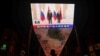 FILE - A giant screen broadcasts news footage of Chinese President Xi Jinping and Russian President Vladimir Putin posing for pictures during a meeting on the sidelines of the Shanghai Cooperation Organization (SCO) summit in Uzbekistan, in Beijing, China, Sept. 16, 2022.