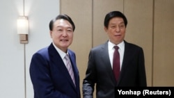 韩国总统尹锡悦（左）在首尔龙山总统府会见到访的中国全国人大常委会委员长栗战书。（2022年9月16日）