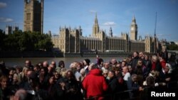 Members of the public line up as they wait to view Queen Elizabeth II's lying in state ahead of her funeral on Monday, in London, Sept. 17, 2022. 