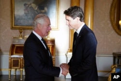 Britain's King Charles III shakes hands with Prime Minister of Canada Justin Trudeau, as he receives realm prime ministers in the 1844 Room at Buckingham Palace in London, Sept. 17, 2022.