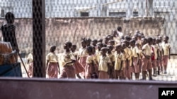 FILE - Pupils stand in line in their school's courtyard in Douala, western Cameroon, on Jan. 13, 2022. Officials in the country say separatist attacks and threats have shut down scores of schools since the school year started on Sept. 5, 2022. 