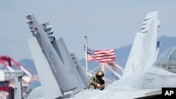 U.S. soldier checks the F/A-18 Super Hornet fighter jet on the deck of the nuclear-powered aircraft carrier USS Ronald Reagan in Busan, South Korea, Sept. 23, 2022.