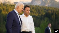 FILE - French President Emmanuel Macron, center, speaks with U.S. President Joe Biden after a group photo at the G7 summit at Castle Elmau in Kruen, near Garmisch-Partenkirchen, Germany, on June 26, 2022. 