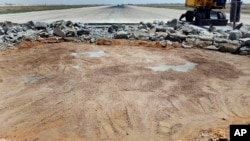 FILE - This photo released by the Syrian official news agency SANA, shows a bulldozer working on a damaged runway of the Damascus International Airport, after it was hit by an Israeli airstrike, in Damascus, Syria, June 12, 2022.