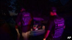 FILE - Police officers stop a car during their night patrol, ahead of curfew hours, in Donetsk region, eastern Ukraine, July 23, 2022.