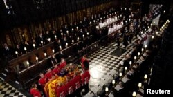 Peti jenazah Ratu Elizabeth II terlihat berada di bagian depan dalam prosesi pemakaman sang ratu di Kapel St George di Kastil Windsor, Berkshire, pada 19 September 2022. (Foto: Pool via Reuters/Victoria Jones)