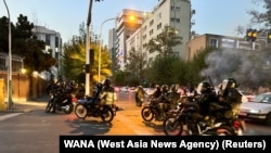 FILE - Police arrive to disperse demonstrators during a protest over the death of Mahsa Amini, a woman who died after being arrested by the Islamic republic's 'morality police', in Tehran, Iran, Sept. 19, 2022.