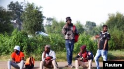 FILE - Job seekers wait beside a road for casual work offered by passing motorists in Eikenhof, south of Johannesburg, South Africa, March 3, 2022.