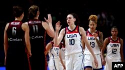 Les joueuses américaines, en blanc, saluent leurs homologues belges lors du match de groupe de la Coupe du monde de basket-ball féminin FIBA 2022 entre les États-Unis et la Belgique à Sydney le 22 septembre 2022.