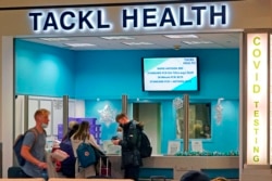 Travelers wait for COVID testing at Pittsburgh International Airport in Imperial, Pa., Dec. 27, 2021.
