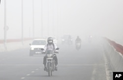 Motorists drive surrounded by smog, in New Delhi, India, Nov. 8, 2017.