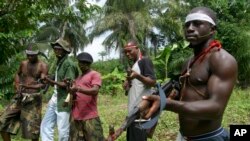 Des militants patrouillent à Okorota, près de Port Harcourt, Nigeria, le 25 juin 2004.
