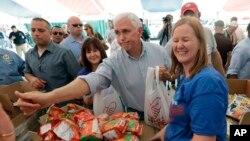 31일 텍사스주 빅토리아 허리케인 '하비' 피해 현장을 방문한 마이크 펜스(가운데) 부통령이 자원봉사자들과 농담을 주고받고 있다.