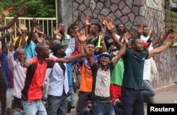 FILE - Protesters pray in front of policemen in front of Notre Dame Cathedral in Kinshasa, Democratic Republic of Congo, Feb. 25, 2018.