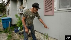 Elmer Sullivan shows the height of floodwater on one of the many times his house has flooded in the small community of Mosby, Missouri, April 24, 2019.